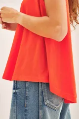 Musculosa blanca de algodón con cuello redondo y sisas amplias.