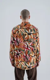 Camisa de manga larga con estampado de flores y hojas en tonos naranja, blanco, rojo, verde y negro.