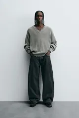 Pantalón de jean negro de corte amplio, estilo balloon fit, con cinco bolsillos y cierre frontal con botones.