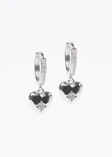 Par de aros dorados con forma de aro pequeño con dije de corazón con un punto de luz.