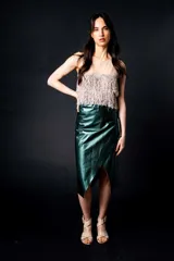 Falda midi de cuero color marrón, de corte recto y estilo portafolio. Se ata en los costados con tiritas.