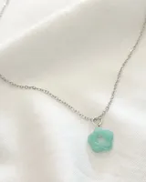 Gargantilla plateada de acero con dije en forma de flor color verde agua.