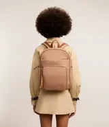Mochila rectangular color beige con detalles en marrón, con bolsillos internos y externos, cierre en cremallera y superficie sin estampa.
