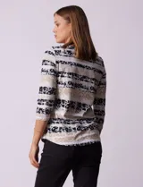 Remera de algodón estampada con rayas horizontales en tonos beige, blanco y negro. Tiene mangas 3/4 y escote a la base.
