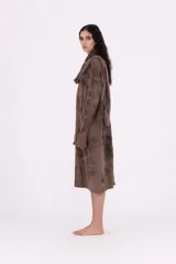 Vestido de tejido de punto gris oscuro con efecto tie-dye o marmolado, silueta amplia y largo midi. Posee cuello tortuga caído y mangas largas con abertura para el pulgar.