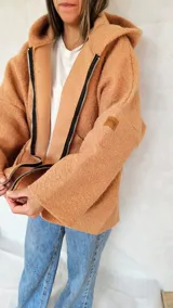 Campera color ocre con capucha y cierre frontal asimétrico.