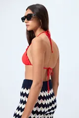 Top de bikini blanco con tirantes finos ajustables al cuello y a la espalda. Presenta volados en el escote y está confeccionado en tejido suave con acabado elástico.