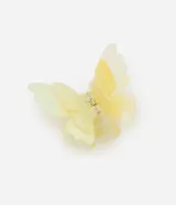 Pinza para el pelo con forma de mariposa doble y efecto marmolado en tonos amarillo y blanco.