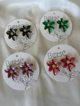 Caravanas negras con diseño de flores y detalles dorados.