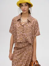 Falda midi marrón con estampado floral en tonos lila, abertura lateral y tiras ajustables.