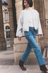 Jeans de tiro alto con bolsillos de plastrón en delantero y espalda, corte mini flare y largo cropped. Cierre frontal con cremallera y botón metálico.