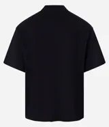 Remera negra de corte boxy, con cuello alto y mangas cortas. Estampa frontal con la palabra "disaster" en tipografía gótica.