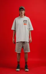 Remera color gris claro de corte oversize, con cuello redondo y mangas cortas. Estampado en la espalda con Mickey y Minnie Mouse sentados sobre una roca, con llamas y el texto 'Hello Darling'.