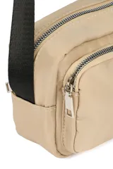 Bandolera color beige con correa larga negra ajustable. Tiene dos compartimentos con cierre y un bolsillo frontal con cierre.