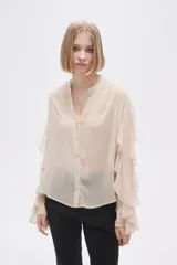 Camisa color crudo de poliéster con cuello mao y mangas largas con volados.