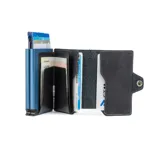 Billetera compacta de cuero negro con costuras contrastantes en azul claro. Presenta un mecanismo de apertura lateral y un detalle en la parte inferior que funciona como abridor de botellas. El nombre de la marca "BALEINE" está grabado en la parte inferior frontal.