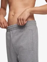 Pantalón de jogging gris de algodón, con cintura elástica, bolsillos laterales y traseros, y logo de Calvin Klein bordado en la pierna izquierda.