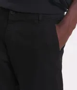 Pantalón de vestir marrón, de corte skinny, con bolsillos laterales y traseros. Se ajusta a la cintura con cinturón de cuero marrón.