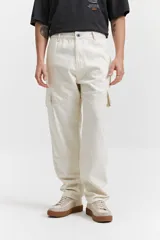 Pantalón cargo color beige, de corte recto, con bolsillos laterales y traseros. Se ajusta a la cintura con cinturón de cuero marrón.