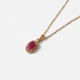Gargantilla de oro amarillo 18k con dije ovalado de rubí rodeado de brillantes.