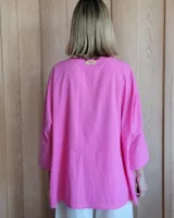 Camisa celeste de corte amplio, con cuello clásico y mangas largas.