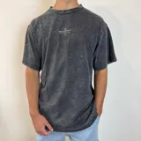 Remera negra con efecto gastado, corte oversize y estampa en la espalda con diseño de mesa con café y texto "Pause & Coffee UW".
