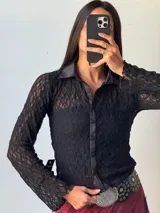 Camisa de encaje negra con cuello clásico y botones frontales.