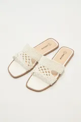 Sandalias bajas color blanco con tiras anchas de tejido trenzado.