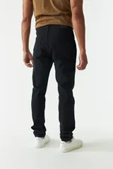 Jean azul oscuro de corte recto, con tiro medio, roturas en la pierna y logo bordado en el bolsillo trasero.