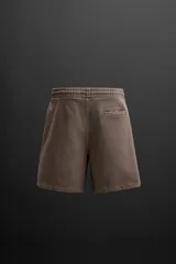 Bermuda jogger negra confeccionada en tejido de algodón con interior de rizo, cintura elástica ajustable con cordón y bolsillos laterales.