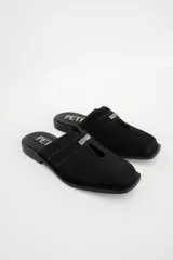 Zuecos con estampado animal print en blanco y negro, con tira ancha de cuero negro y aplique metálico.