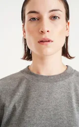 Remera gris melange de corte crop y calce oversize, con hombros caídos y cuello redondo.