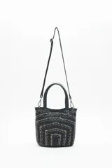 Cartera tote negra de cuero vacuno con tachas metálicas plateadas y doradas. Tiene doble asa corta y correa larga desmontable. Forro interior de algodón.