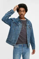 Campera de jean celeste de corte clásico, con cuello de punta, cierre frontal con botones metálicos, mangas largas con puños abotonados, bolsillos con solapa abotonados en el pecho y bolsillos laterales.