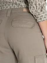 Pantalón de cargo color beige, de corte recto y tiro alto, con bolsillos laterales tipo carpintero y cierre con botón y cremallera.