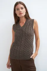 Chaleco tejido marrón con escote en v y sisas amplias. Diseño con diferentes puntos combinados en el frente.