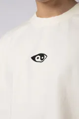 Remera negra de corte oversize con cuello redondo y mangas cortas. Estampado pequeño en el frente y parche estampado en la espalda.