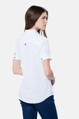 Camisa blanca de lino y algodón, con cuello clásico, mangas cortas y cierre frontal parcial con botones.