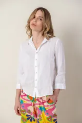 Camisa blanca de lino con cuello clásico, abotonada al frente y mangas 3/4 con puños.