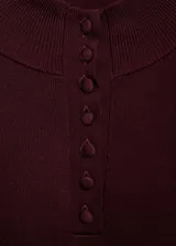 Jersey negro de punto fino con cuello perkins y cierre de botones.