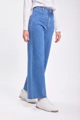 Pantalón jean ancho de tiro alto, color azul medio, con terminación desflecada en el ruedo.