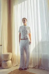 Blusa blanca con estampado de flores y cuello mao, con cierre frontal de botones.