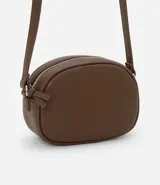 Cartera tipo camera bag color marrón, con forma redondeada, correa ajustable, cierre superior y superficie texturizada.