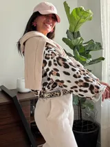Blusón de seda color blanco con estampado animal print en tonos marrón y negro. Tiene corte amplio, mangas largas ajustables y cuello redondo.