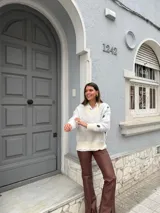 Sweater gris con estampado de flores blancas, cuello en V y mangas largas.