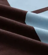 Remera de algodón color marrón con cuello redondo y ribetes en las mangas y cuello en color celeste. Presenta el número "86" estampado en grande en color celeste en el frente.