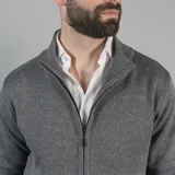 Campera tejida azul marino con cierre frontal, cuello alto y bolsillos laterales.