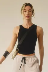 Top deportivo negro, corte musculosa, ajustado al cuerpo, con escote redondo y espalda cerrada.