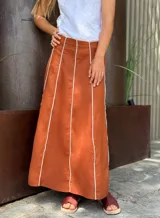 Conjunto de top con breteles finos y pollera larga marrón con líneas verticales blancas.