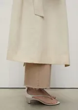 Pantalón de jeans color beige, corte culotte, tiro alto, con cierre de cremallera y botón, bajo deshilachado y bolsillos de parche en la parte posterior.